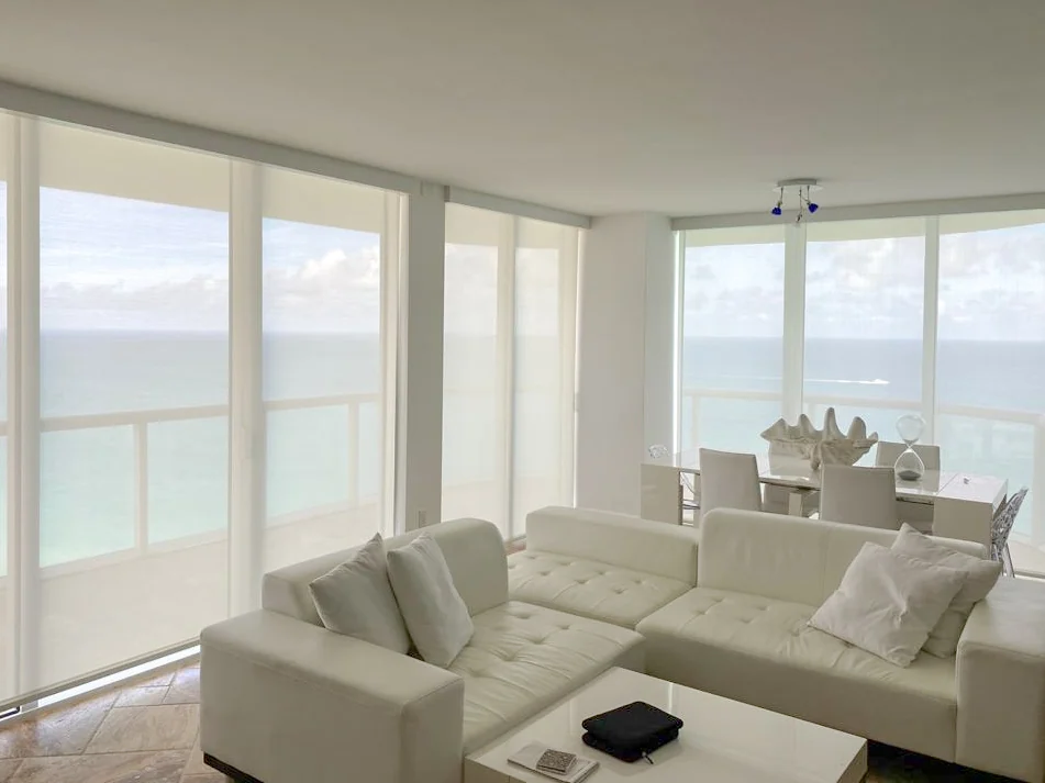 Motorized roller shades in a waterfront interior